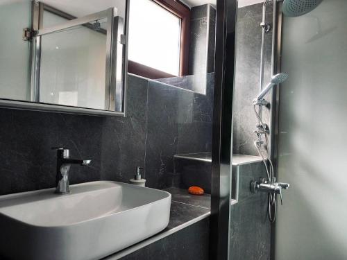a bathroom with a sink and a mirror and a shower at Moxy Paxos in Makrátika