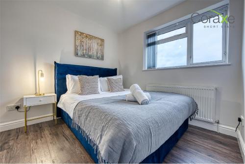 a bedroom with a blue bed with a window at 3 Bedroom Luxe Living for Contractors and Families by Coraxe Short Stays in Dudley