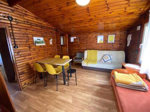 um quarto com uma mesa e cadeiras num chalé de madeira em Domki Promyk em Mrzeżyno