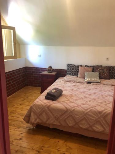 een slaapkamer met een groot bed en een bruine deken bij R&B Vendégház in Balatonakarattya