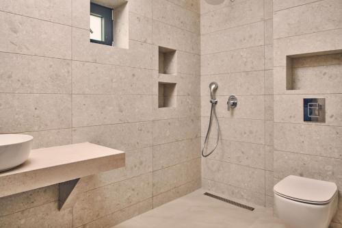 a bathroom with a shower with a toilet and a sink at Sea Front Zante Apartments in Zakynthos Town
