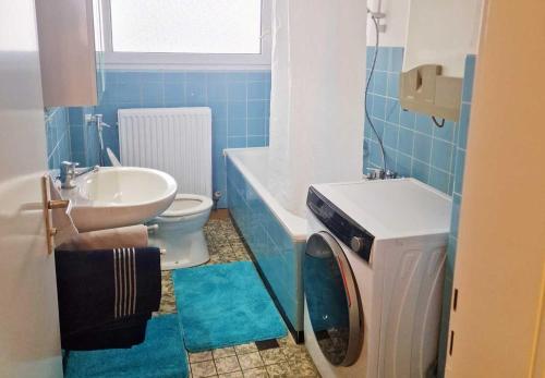 uma casa de banho com um lavatório e uma máquina de lavar roupa em City-Apartment Heidelberg em Eppelheim