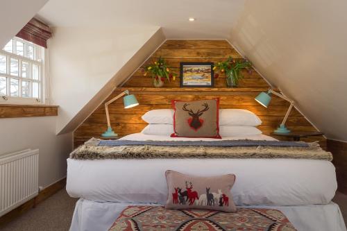 una camera da letto con un grande letto in mansarda di Crofts of Cairngrom a Nethy Bridge