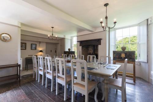 una sala da pranzo con tavolo e sedie bianchi di Almsbury Farmhouse a Winchcombe