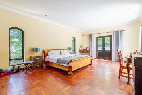 a bedroom with a bed and a wooden floor at Lovely Family home in Bryanston in Johannesburg
