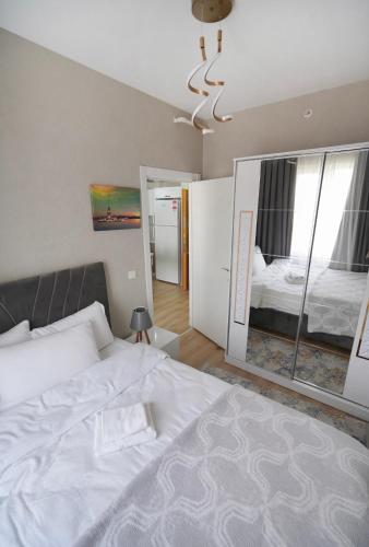 a bedroom with a large white bed and a mirror at Classic Suite TS23 in Esenyurt