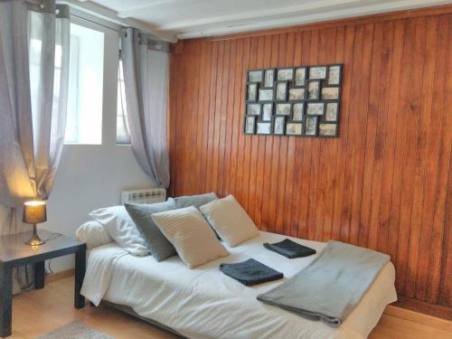 a bedroom with a bed with a wooden wall at Le Gîte du Chêne Rouvre in Corbeil-Cerf