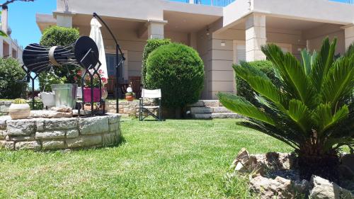 a house with a yard with a fountain in the grass at Modern Villa in Chania in Perivólia