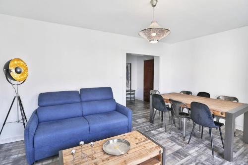 a living room with a blue couch and a table at Bel appartement à 100m de la plage in Les Sables-d'Olonne