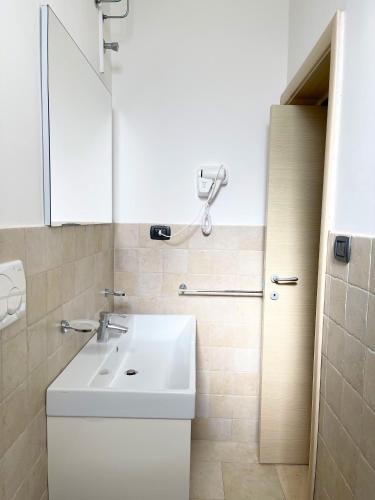 a bathroom with a white sink and a mirror at Appartamenti le Conchiglie 1 by Ferrocino Holiday in Lido Conchiglie