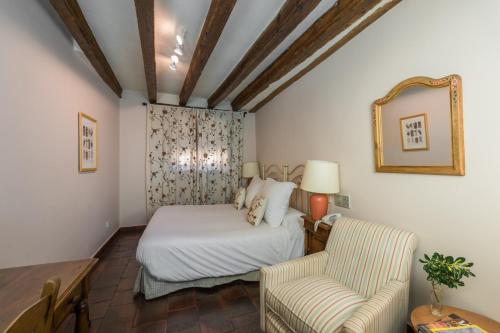 a bedroom with a bed and a couch and a chair at Posada Real Mingaseda in Navafría