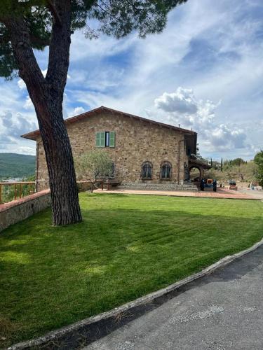 a large stone building with a tree in front of it at Casa M Tuscany in Chianciano Terme