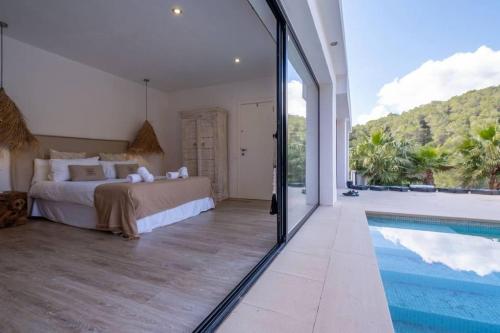 a bedroom with a bed and a swimming pool at Villa Venus in Ibiza Town