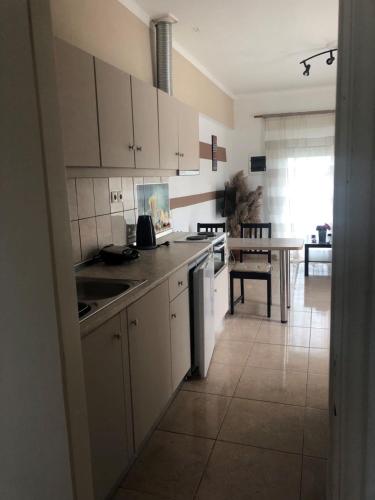 a kitchen with white cabinets and a table at Toula's Apartments in Faliraki