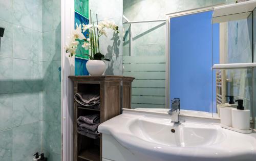 W łazience znajduje się umywalka i lustro. w obiekcie Marceau Central Flat w Nicei