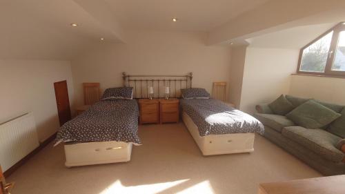 a living room with two beds and a couch at Rosebank Lodge in High Bentham