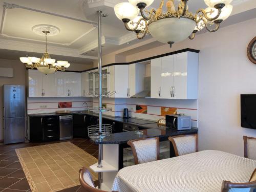 a kitchen with white cabinets and a chandelier at Park Azure Residence in Baku