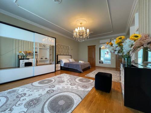 a large living room with a bed and a chandelier at Park Azure Residence in Baku