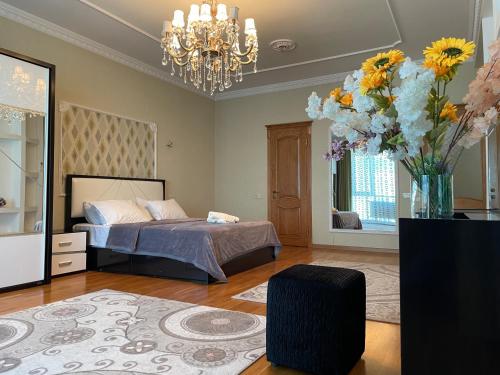 a bedroom with a bed and a vase of flowers at Park Azure Residence in Baku