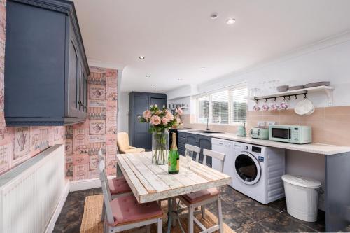 a kitchen with a table with a vase of flowers on it at The Laurel Cottage in Doncaster