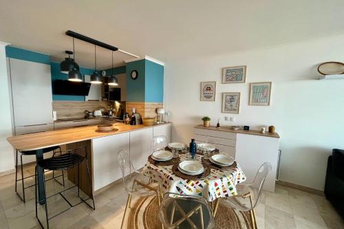 a kitchen with a table with chairs and a dining room at Accès direct à la Plage Garage fermé in Les Sables-dʼOlonne