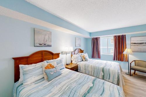 ein blaues Schlafzimmer mit 2 Betten und einem Stuhl in der Unterkunft Roxanne Towers PH1 in Myrtle Beach