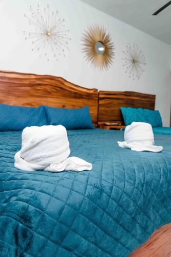 a blue bed with two white towels on it at Hotel Naomi City center in Bacalar