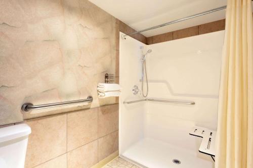a bathroom with a shower and a toilet at Days Inn by Wyndham Seatac Airport in SeaTac