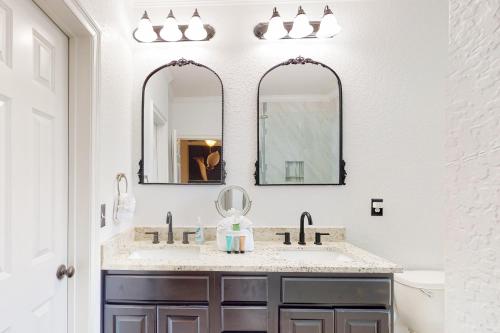 a bathroom with two sinks and two mirrors at Cassie's Beach Cottage in Destin
