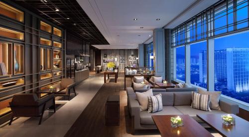 un vestíbulo de hotel con sofás, mesas y ventanas en Grand Hyatt Macau en Macao