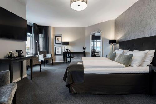 um quarto de hotel com uma cama grande e uma secretária em Best Western Plus Hotel Kronjylland em Randers