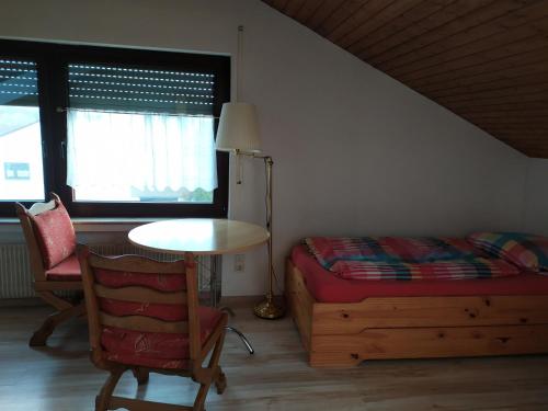 1 dormitorio con 1 cama, 1 mesa y 1 silla en Fewo-Neschtle, en Vaihingen an der Enz
