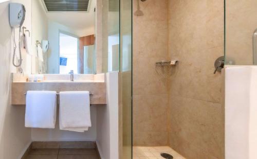 La salle de bains est pourvue d'une douche et d'un lavabo. dans l'établissement Sleep Inn Leon Antares, à León