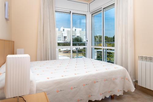 ein Schlafzimmer mit einem Bett und einem großen Fenster in der Unterkunft AT083 Bonita casa con piscina y barbacoa, zona muy tranquila in Creixell