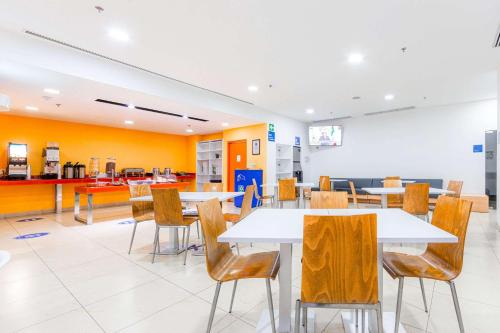 a dining room with tables and chairs in a restaurant at Sleep Inn Leon Antares in León