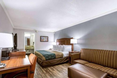 une chambre d'hôtel avec un lit et un canapé dans l'établissement Travelodge by Wyndham Canton-Livonia Area, MI, à Canton