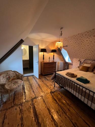 a bedroom with a bed and a chair and a mirror at Maison d'hôtes de la prison en toutes libertés in Espalion