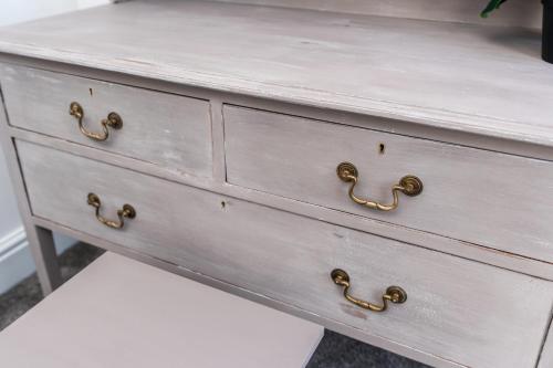 a white dresser with gold hardware on it at The Laurel Cottage in Doncaster