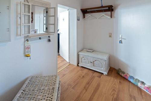 a room with a white refrigerator and a wooden floor at Friesenbiene in Dornumersiel