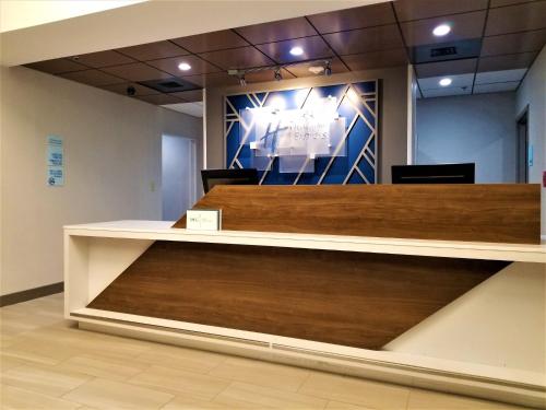 a reception counter in a building with wood at Holiday Inn Express Apex - Raleigh by IHG in Apex