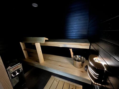 un pequeño banco de madera en una habitación oscura en Townhouse with SAUNA&FREE PARKING close to Santa Claus Village & Santa Park, en Rovaniemi