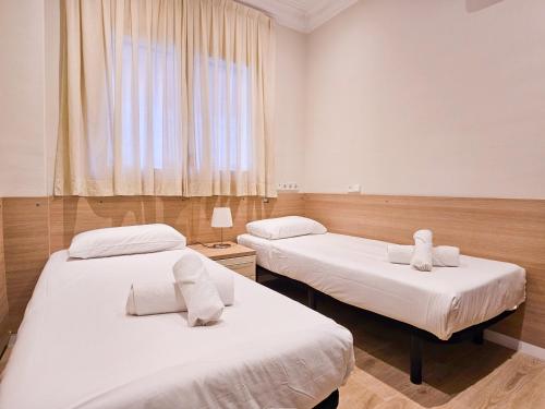2 camas en una habitación con ventana en Classbedroom Park Güell Apartment, en Barcelona