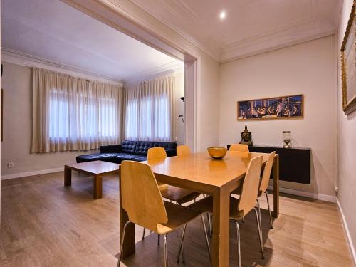 Classbedroom Park Güell Apartment في برشلونة: غرفة طعام مع طاولة وكراسي وأريكة