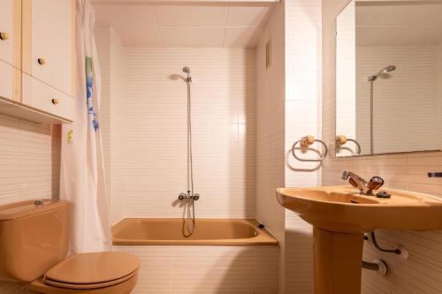 Un baño con bañera, lavabo e inodoro. en AT046 Els Pins, 1ra línea de la playa, piscina, airco, aparcamiento, en Torredembarra