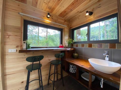 baño en una cabaña de madera con lavabo y 2 taburetes en Sausau Garden, a pefect retreat for relaxing, close to Noi Bai airport, en Sóc Sơn