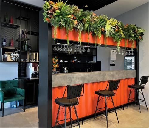 a bar with chairs and plants on the wall at World Class Airport Hotel in Arnavutköy