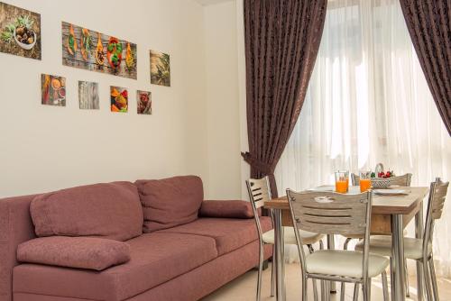 a living room with a couch and a table with chairs at Cascadas Holiday Apartments in Sunny Beach