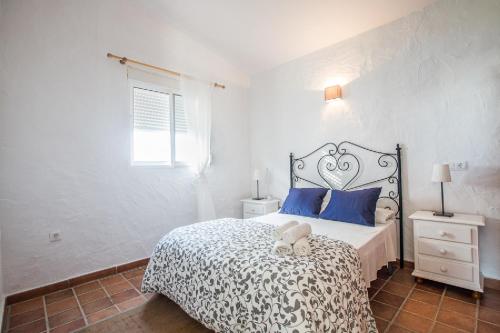 um quarto com uma cama grande e almofadas azuis em BOLONIA HOUSE em Tarifa
