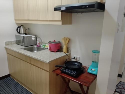 uma cozinha com um balcão com um lavatório e um fogão em Traveller Residence by Celandine em Manila