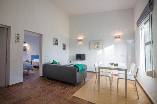 uma sala de estar com uma mesa e um sofá em BOLONIA HOUSE em Tarifa